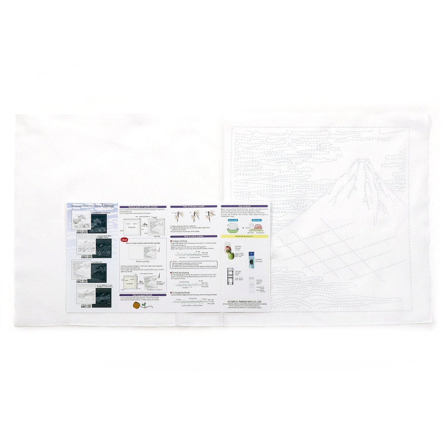 a white cloth with various printed materials, including a large drawing of a mountain and several smaller printed pages with text and diagrams.