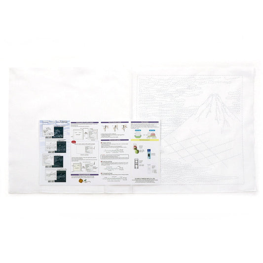 a white cloth with various printed materials, including a large drawing of a mountain and several smaller printed pages with text and diagrams.