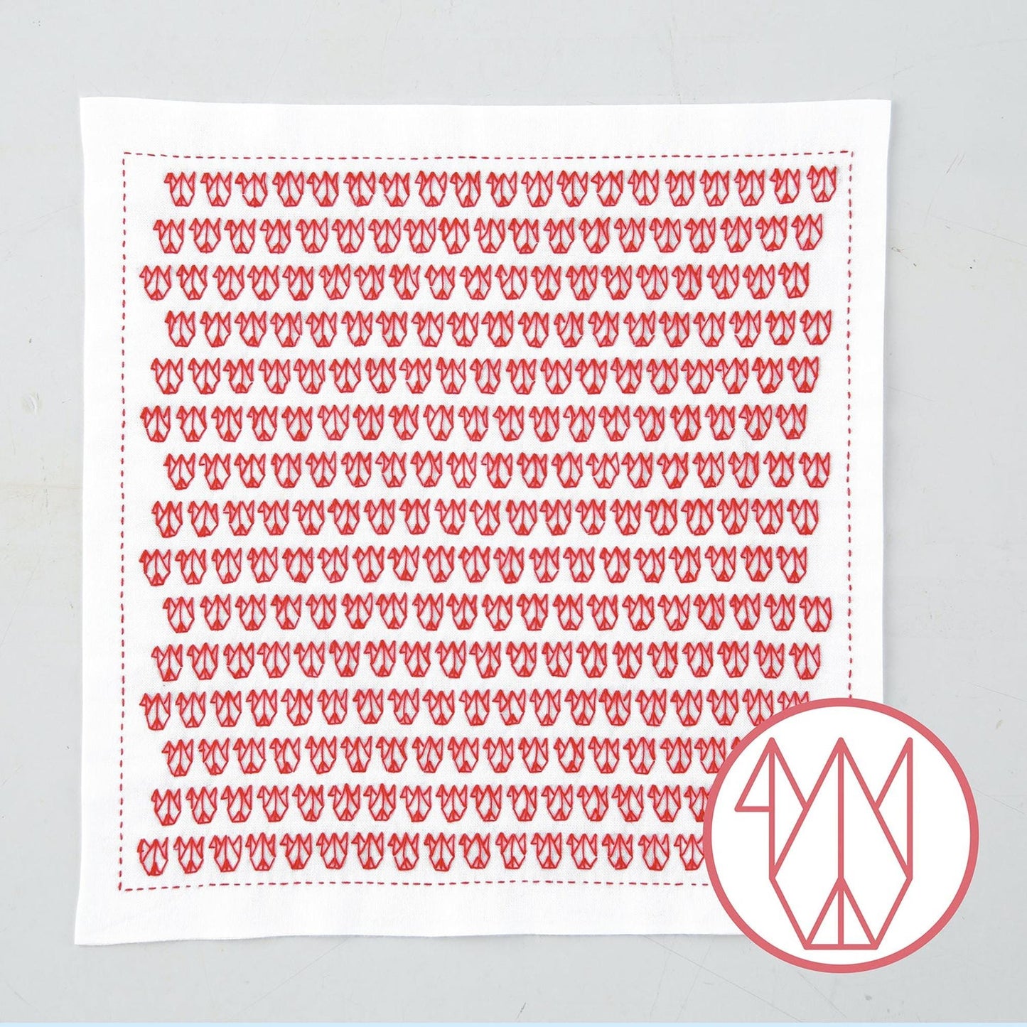a square piece of fabric with a repeating pattern of red flowers or butterflies.