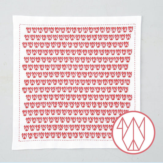 a square piece of fabric with a repeating pattern of red flowers or butterflies.