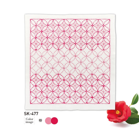 a square with a pink and white geometric pattern, and there is a single red flower next to it.