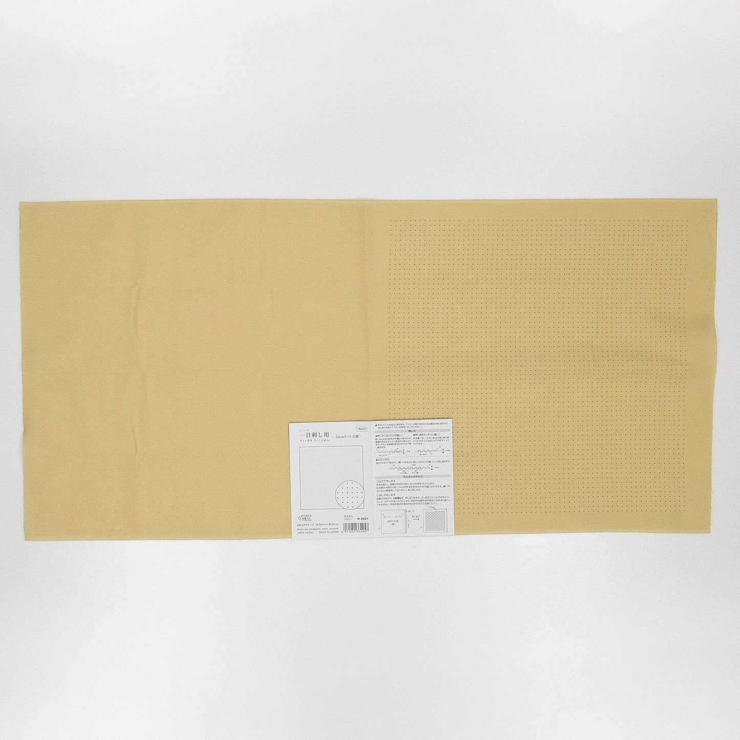 The image is a plain, light-colored fabric with a label attached to it, which appears to be a piece of paper or a printed document.