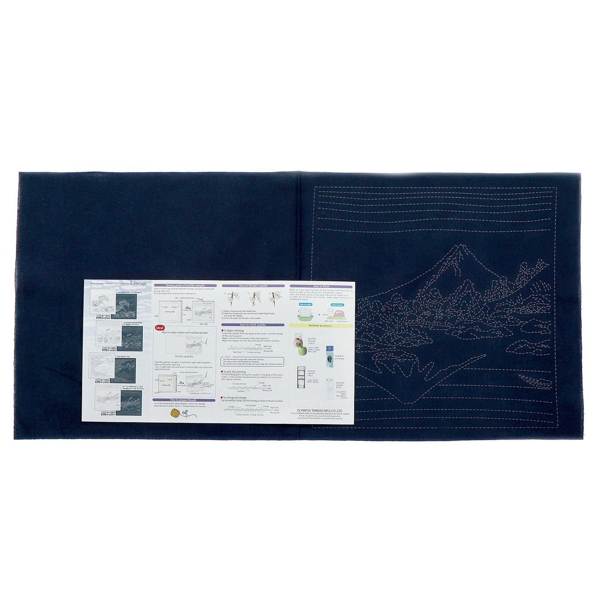 The image is a black and white photograph of a folded piece of paper with instructions and diagrams, placed on a dark surface.