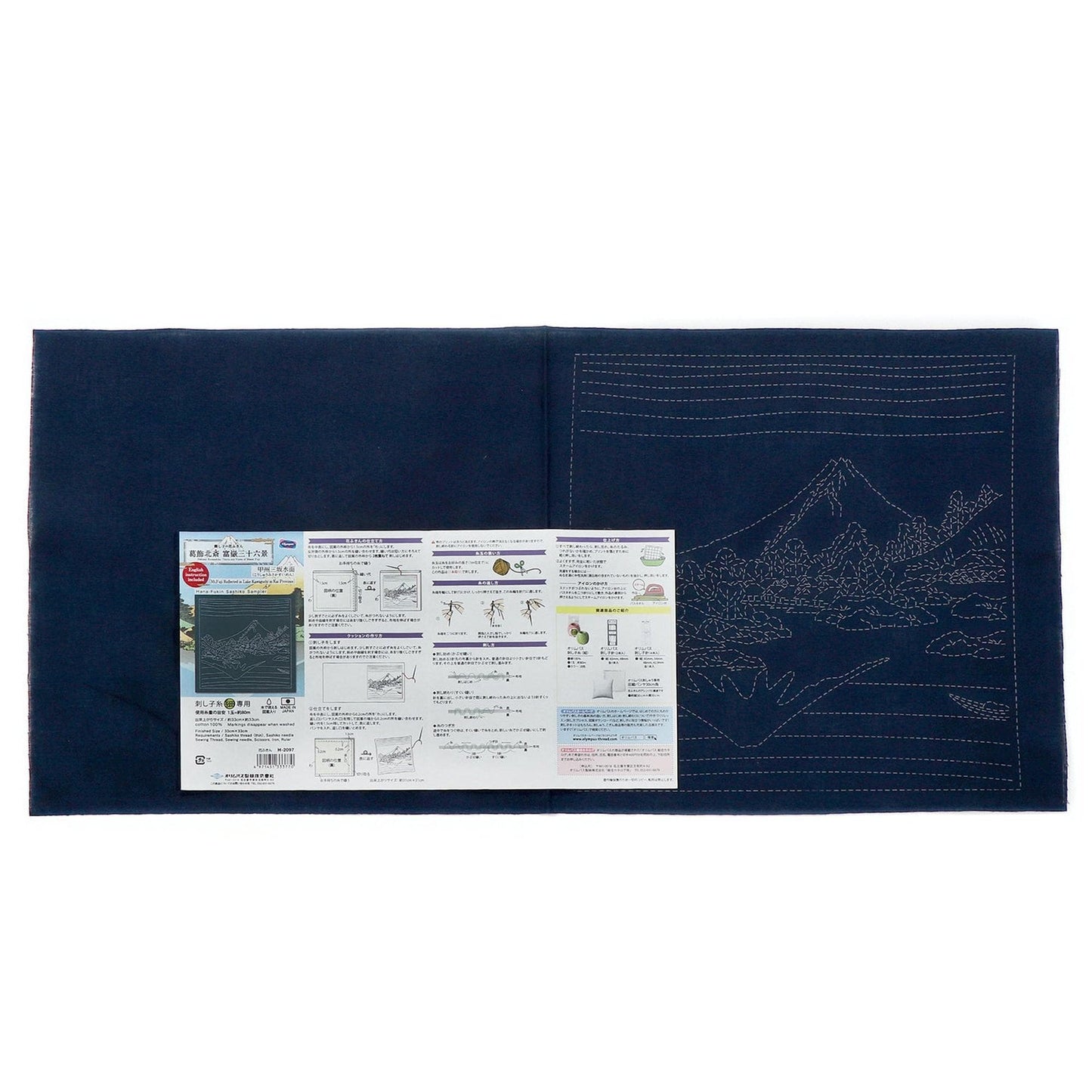The image is a blue fabric with a detailed embroidery design on it, along with a printed instructional guide or diagram.