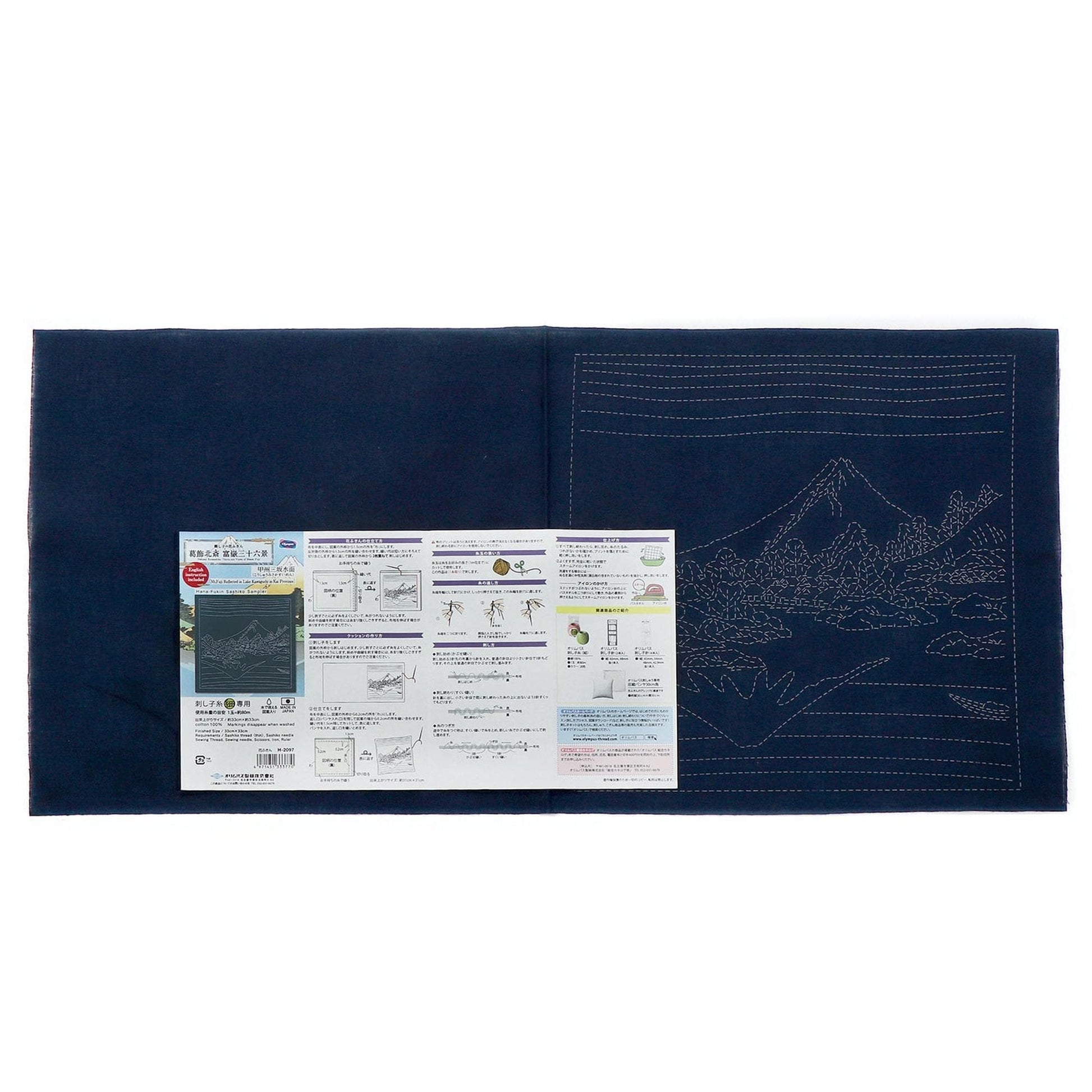 The image is a blue fabric with a detailed embroidery design on it, along with a printed instructional guide or diagram.