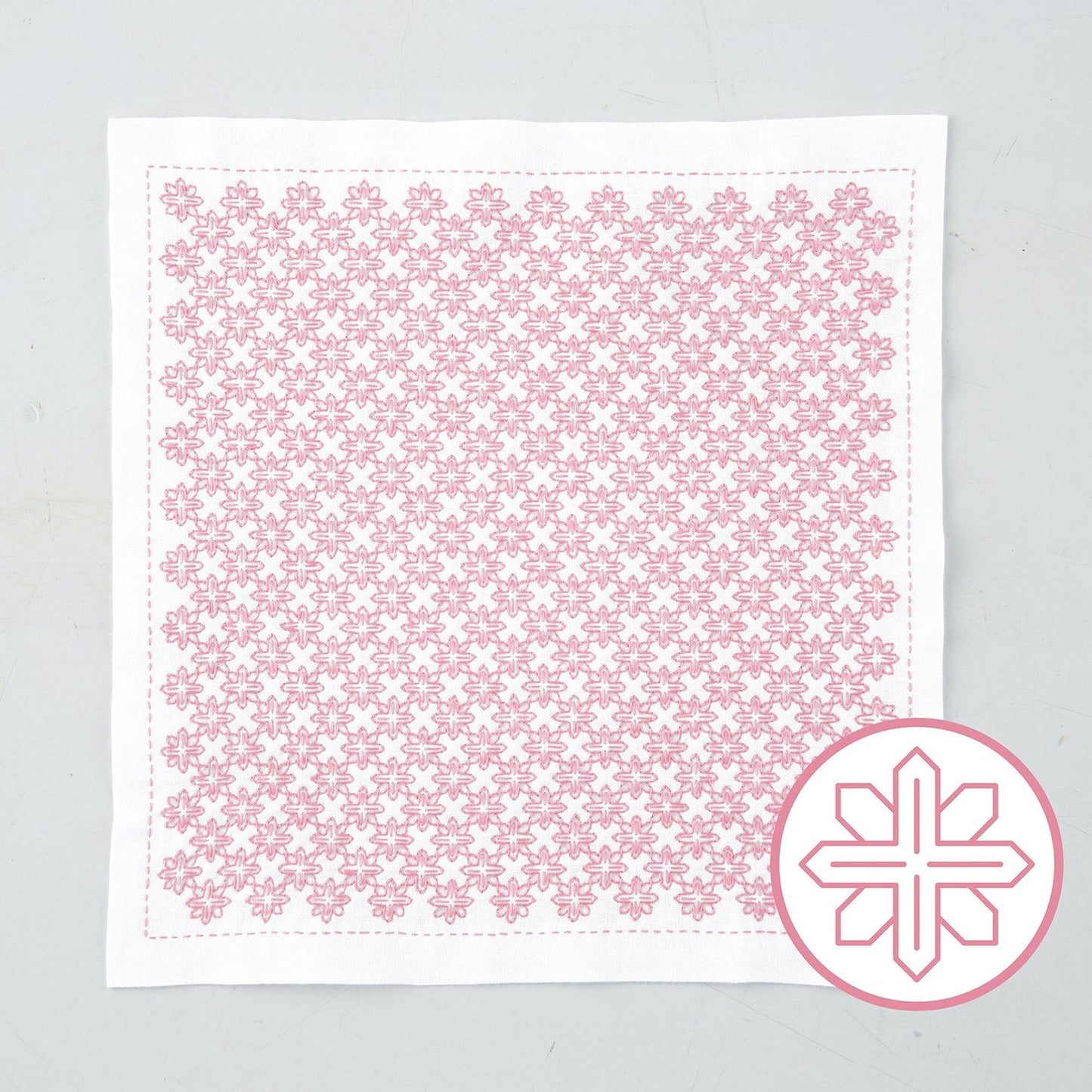 a square piece of fabric with a repeating pink floral pattern.