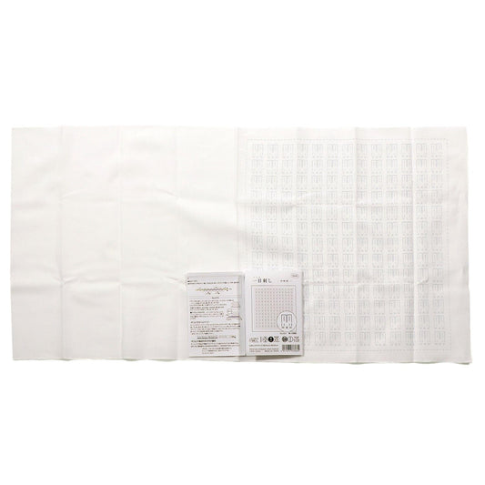 a white cloth with a grid pattern, and there is a small white paper with text and a barcode next to it.
