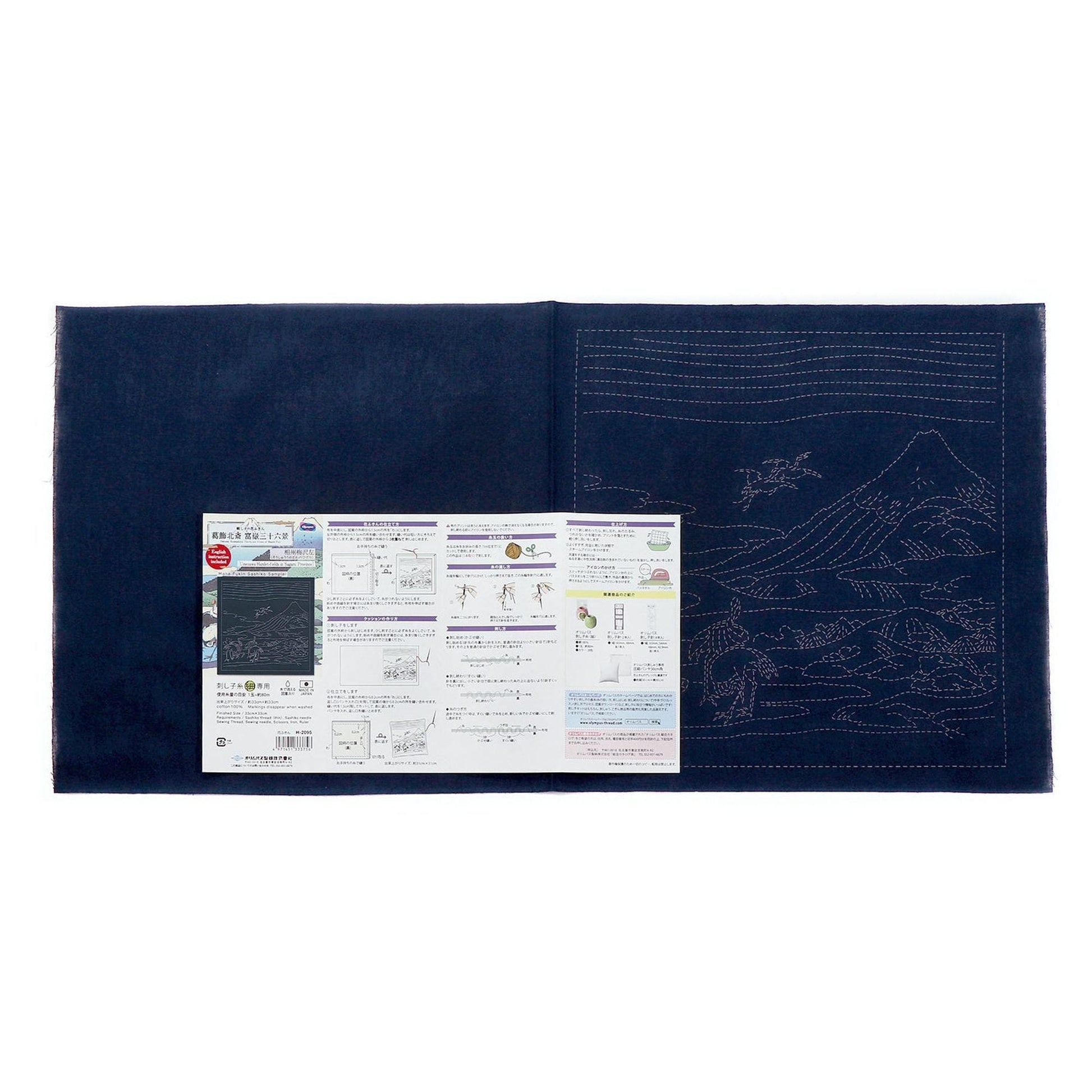 The image is a large blue fabric with a detailed embroidery design on it. The fabric appears to be a piece of cloth or material, possibly used for sewing or other textile-related activities.