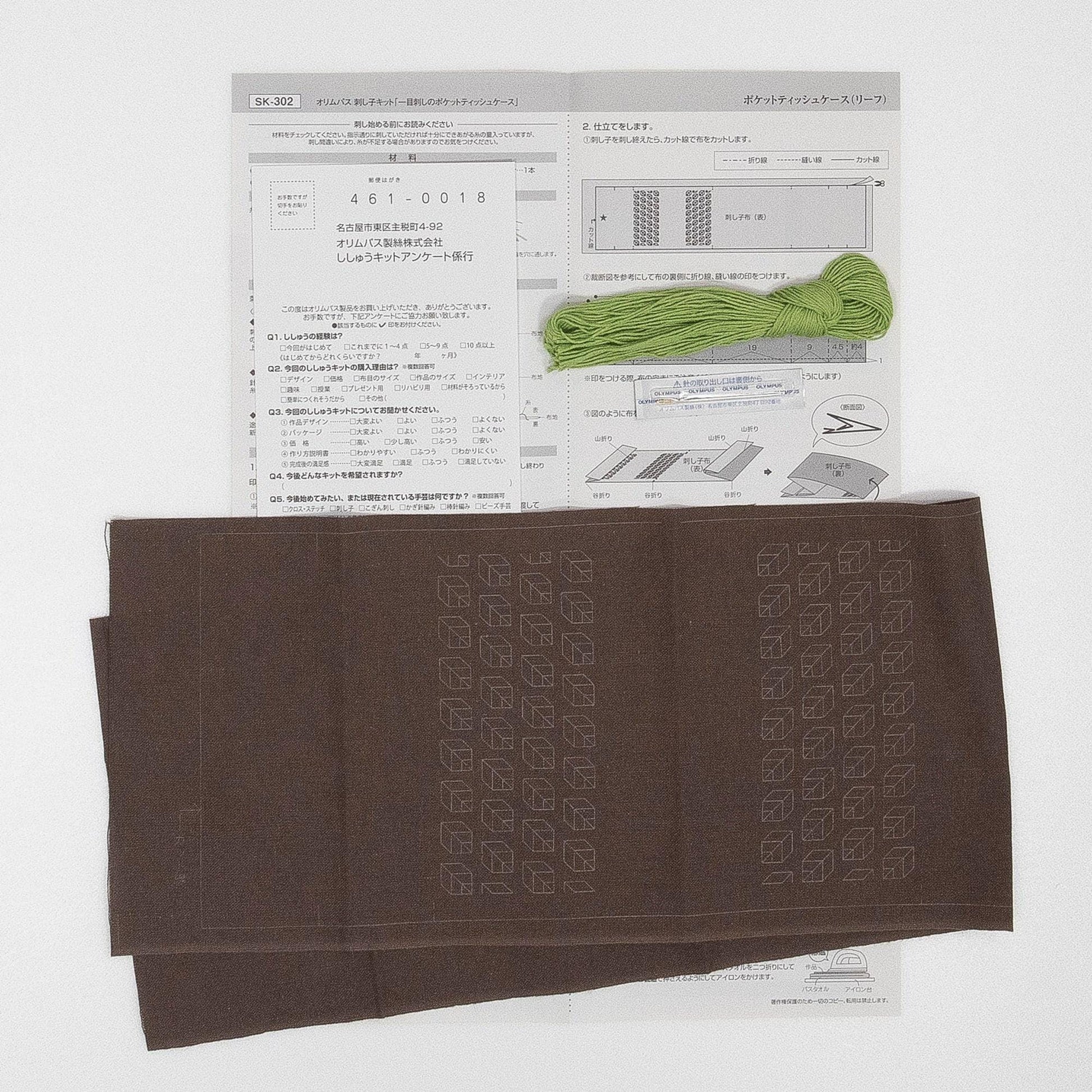 a brown fabric with a green string or thread attached to it, along with some text and diagrams, suggesting it is a sewing or crafting project.