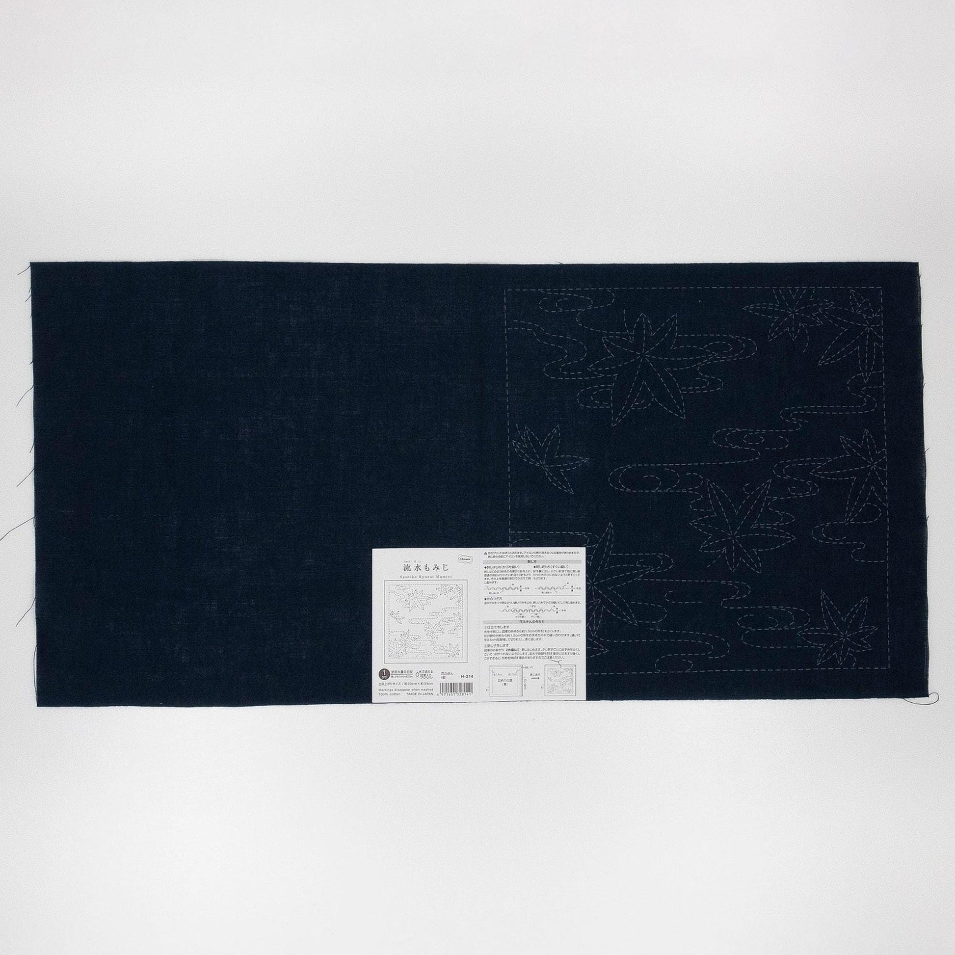 The image is a dark blue fabric with a white label attached to it, which appears to be a piece of paper with text and possibly a map.