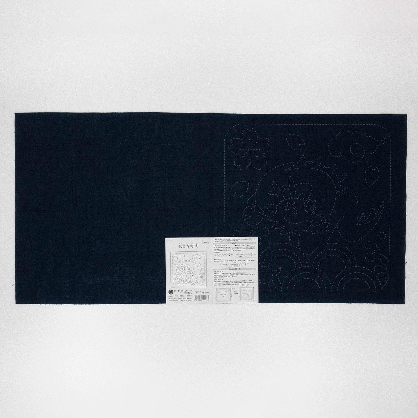 The image is a black fabric with a white label attached to it, which appears to be a sewing pattern or instructions.