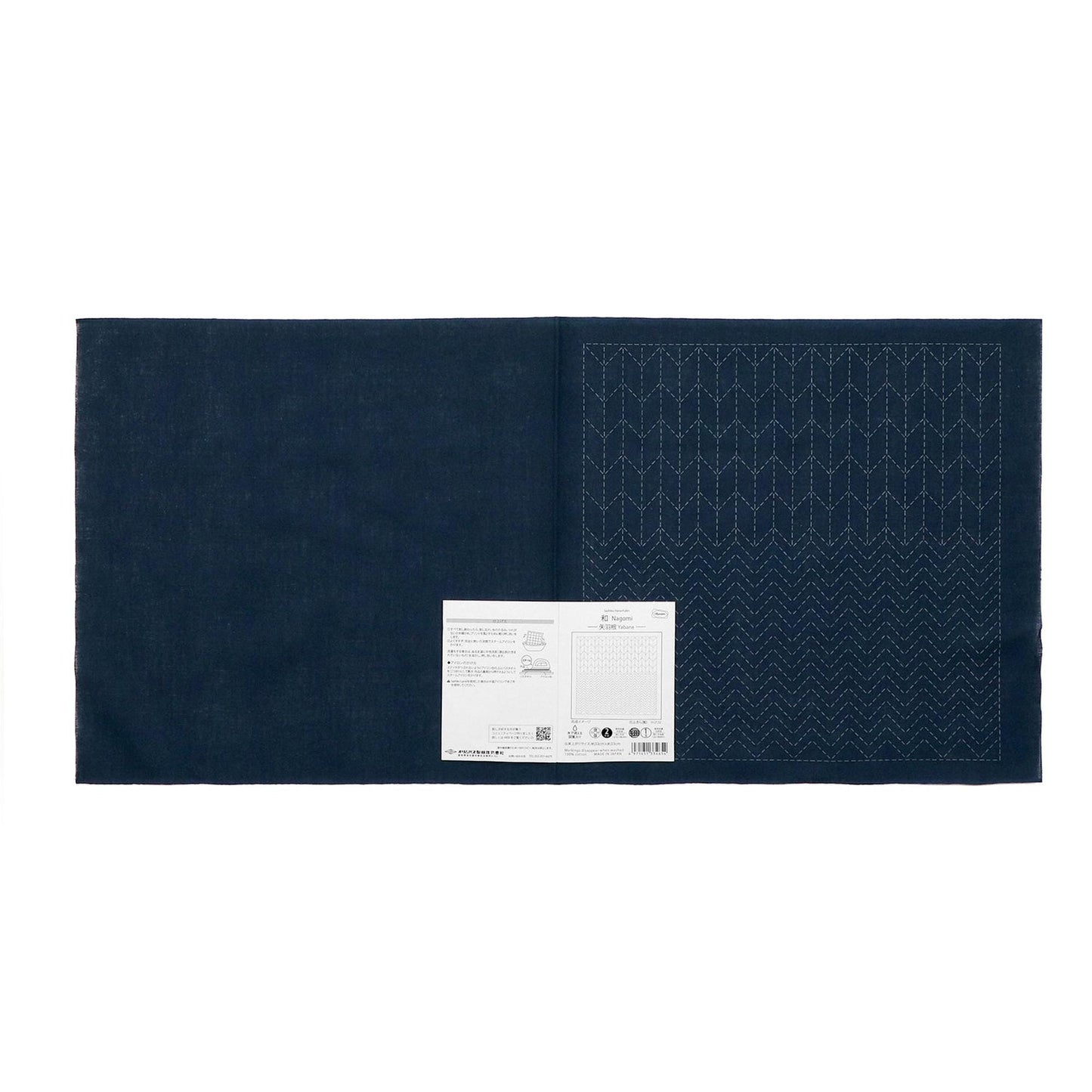 The image is a dark blue fabric with a white label attached to it, which appears to be a piece of paper or a printed document.