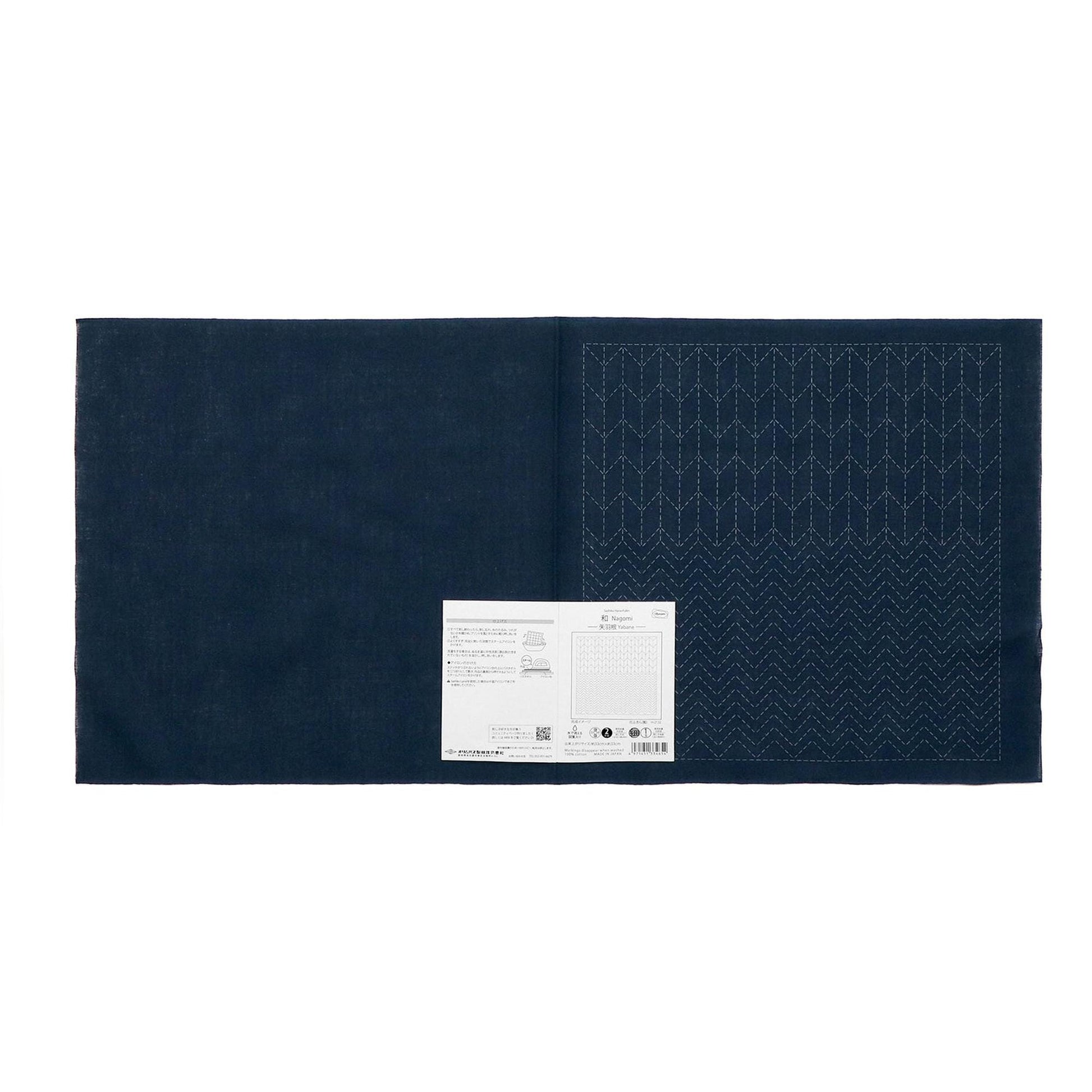 The image is a dark blue fabric with a white label attached to it, which appears to be a piece of paper or a printed document.
