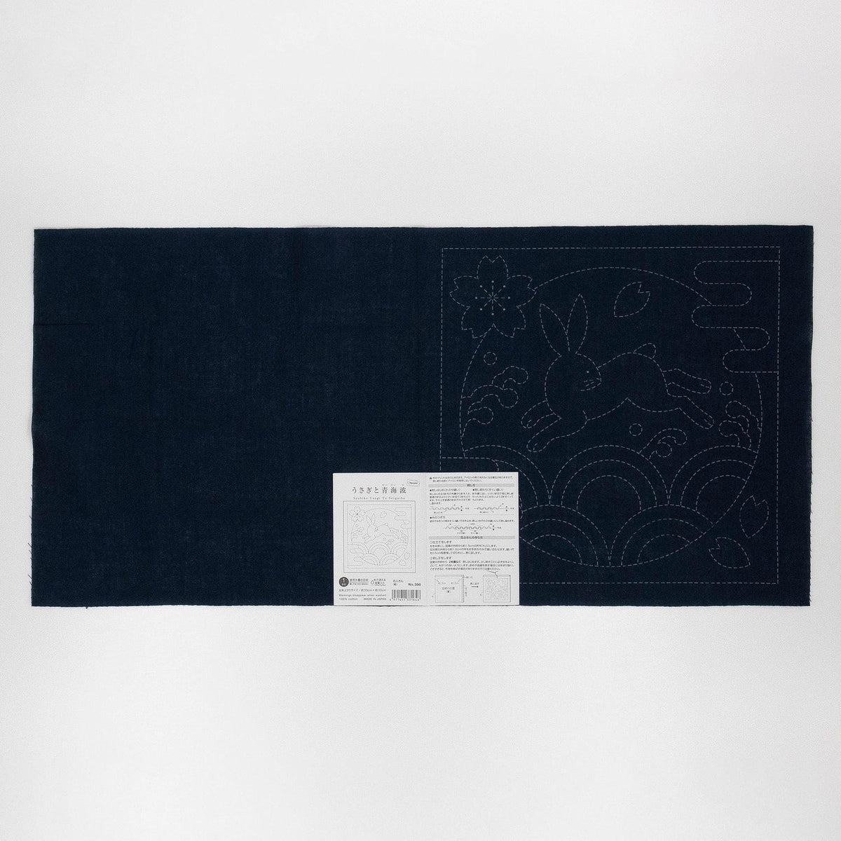 The image is a dark blue fabric with a white label attached to it, which appears to be a sewing pattern or instructions.