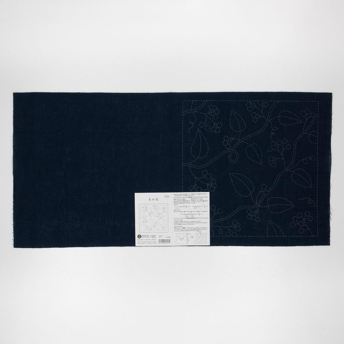 The image is a dark blue fabric with a white label attached to it, which appears to be a sewing pattern or instructions.