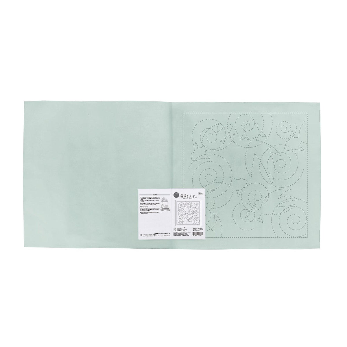 The image is a light green square with a white label attached to it, which appears to be a piece of paper with instructions or information.