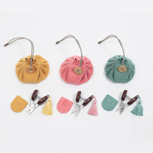 a collection of colorful fabric pouches, scissors, and tassels arranged on a white background.