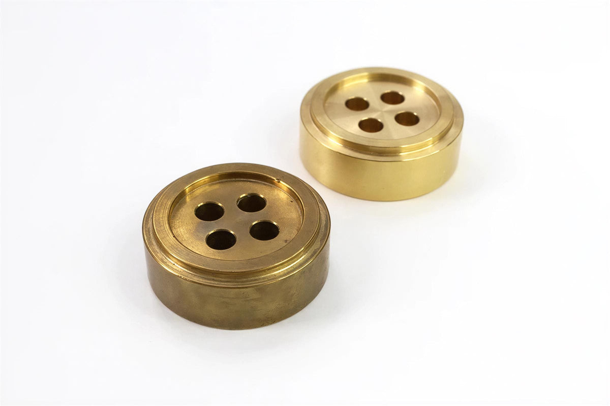 two brass components with a button-like design, placed on a white background.