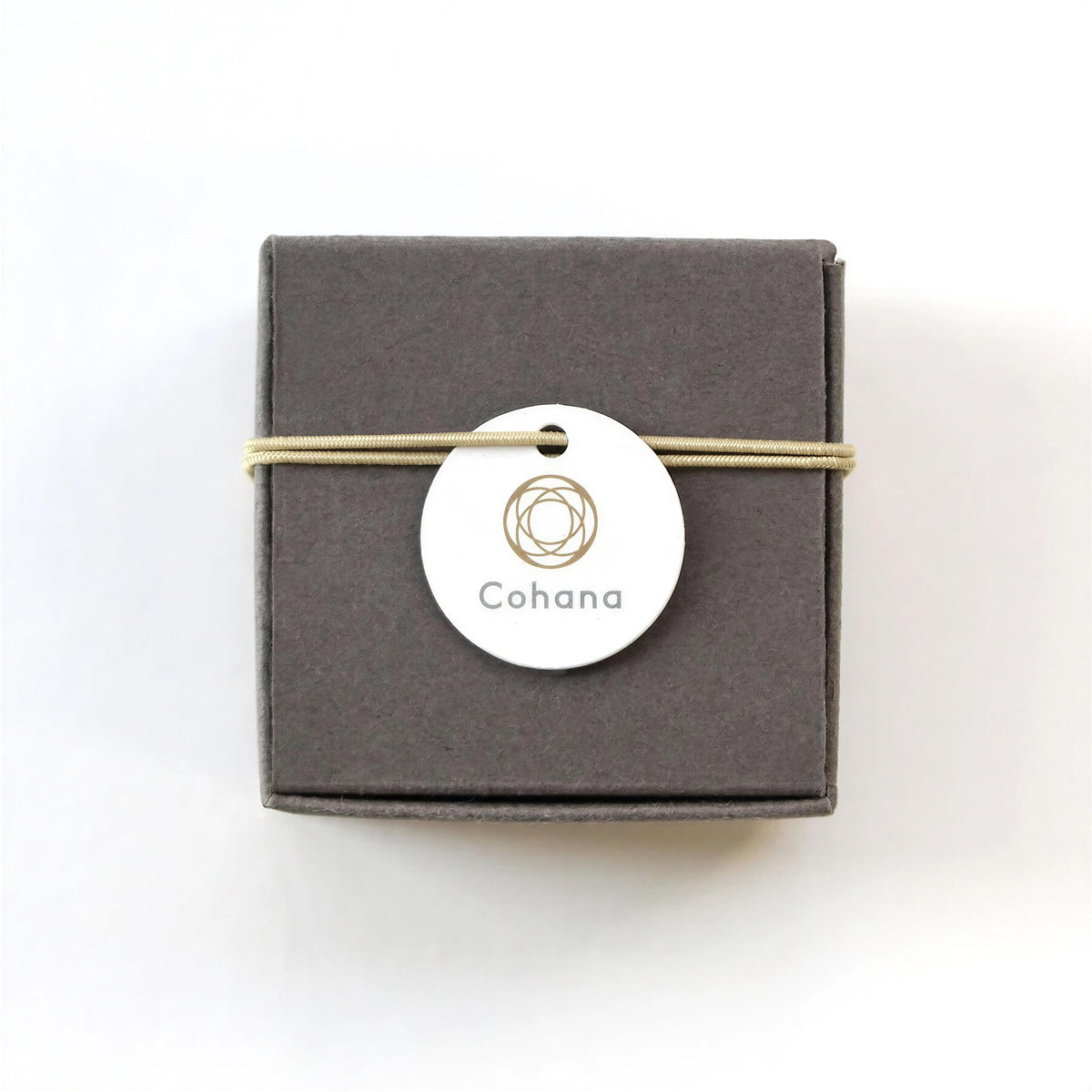 A gray box with a round white tag attached, displaying the text "Cohana" in a stylized font.