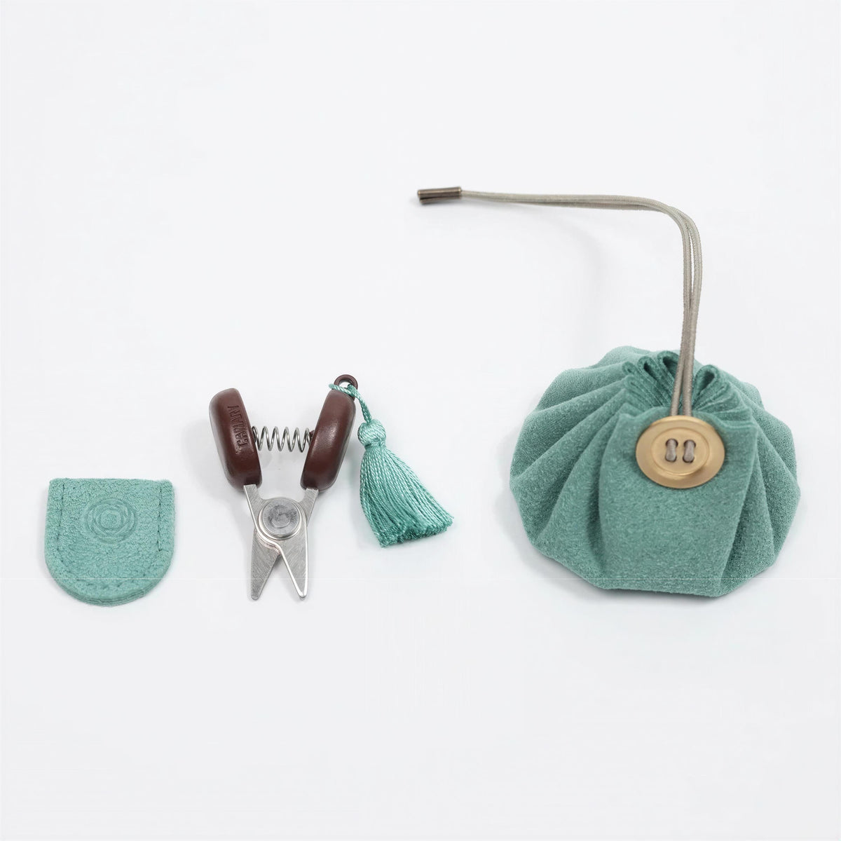 A pair of scissors, a tassel, and a small bag or pouch are arranged on a white background.