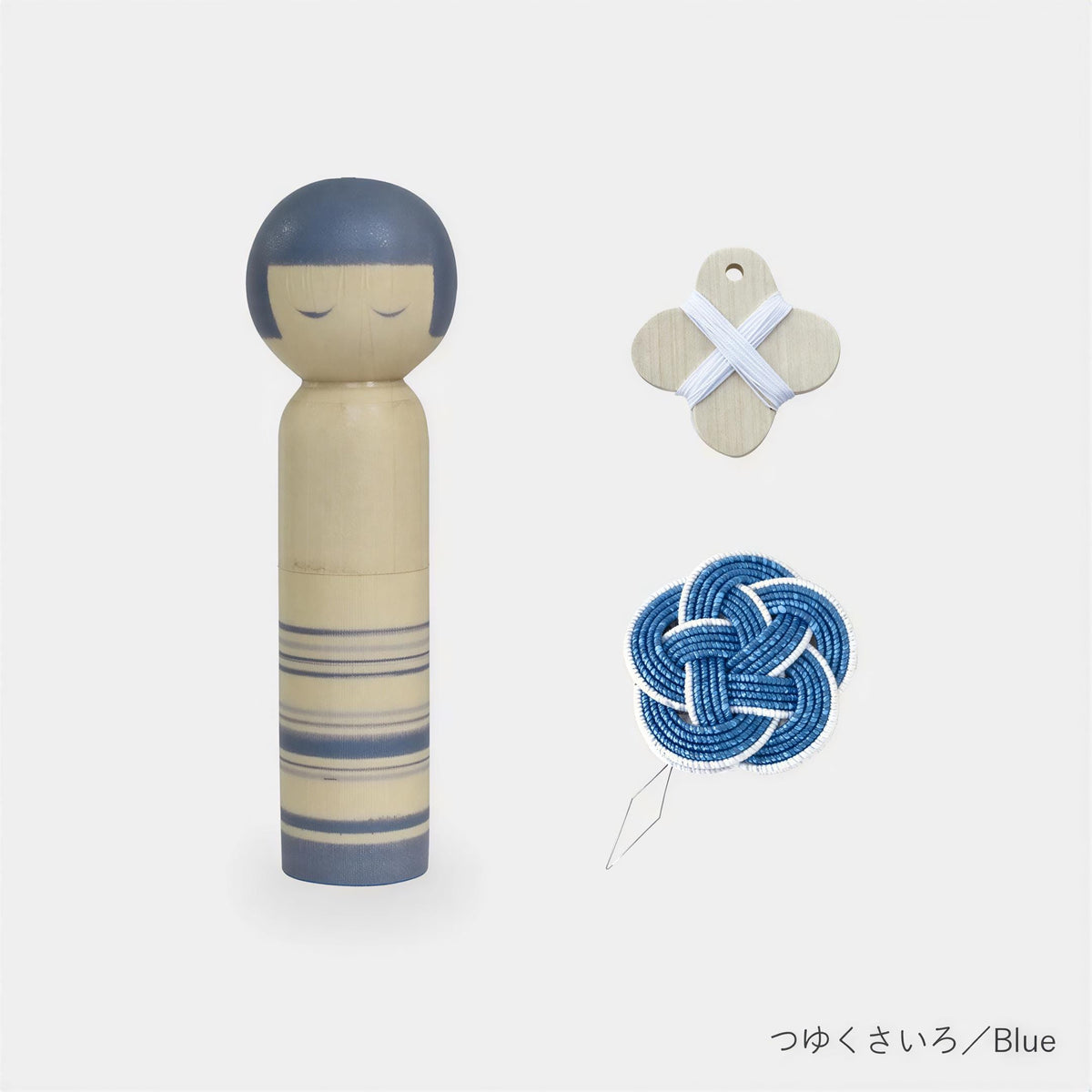 a wooden doll, a blue and white knot, and a small wooden tag.
