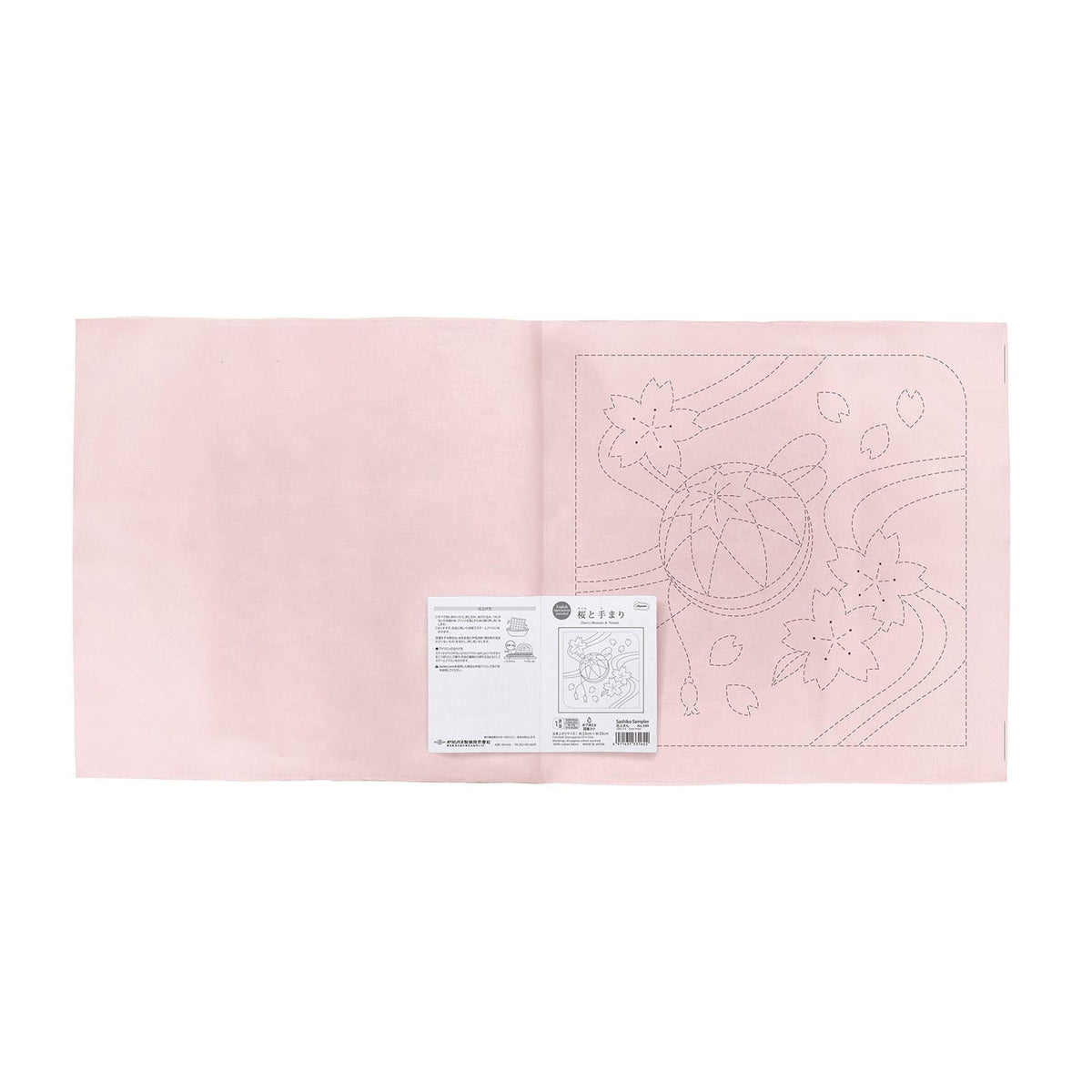 The image is a pink fabric with a printed design on it, and there is a small white label with text next to it.