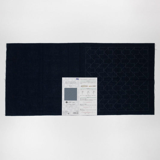 The image is a black fabric with a pattern on it, and there is a piece of paper with instructions or information about the fabric.