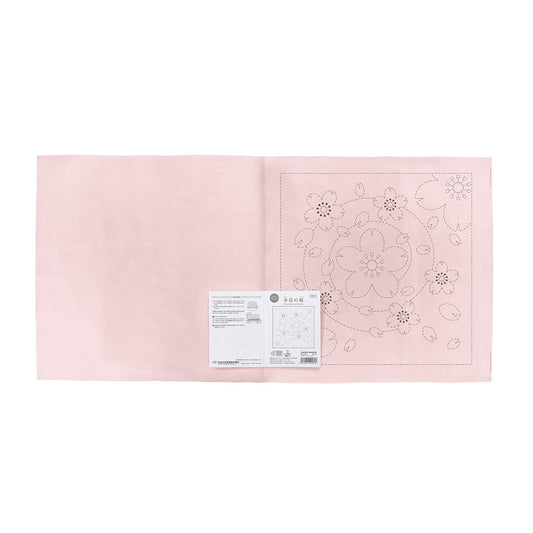 a pink fabric with a floral pattern and a small white label with text and diagrams.