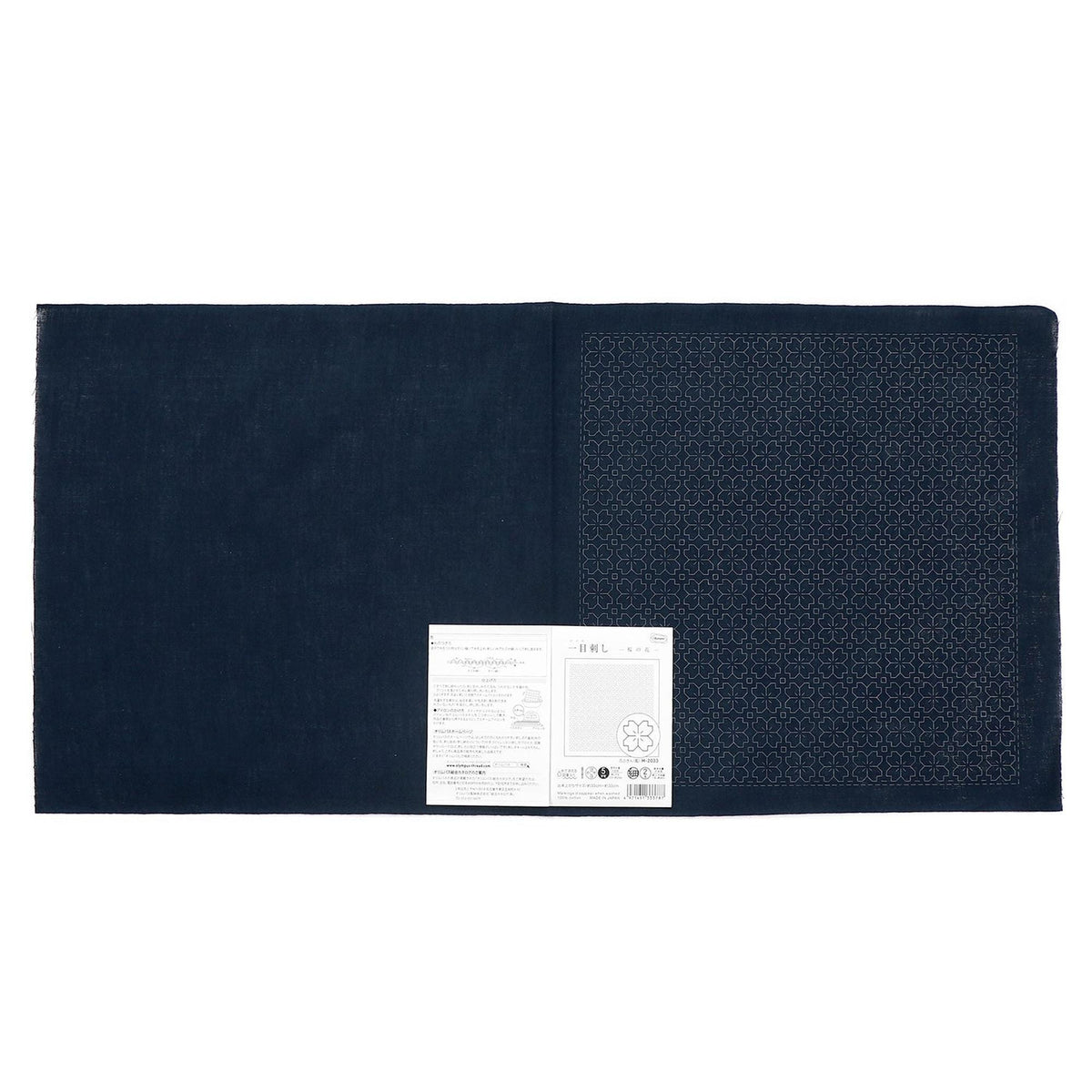 The image is a dark blue fabric with a white label attached to it, which appears to be a piece of paper or a printed document.
