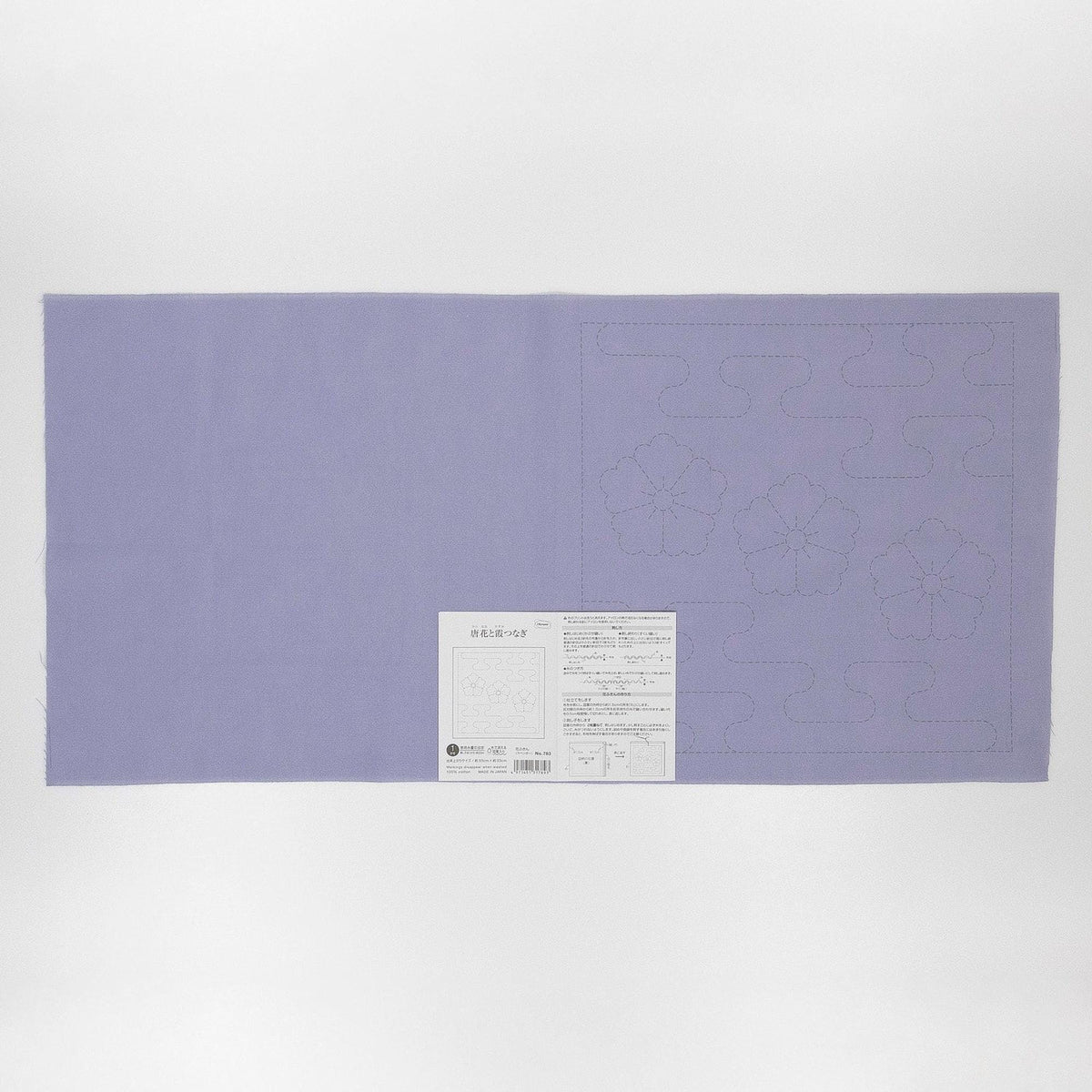 The image is a large purple fabric with a white label attached to it, which appears to be a sewing pattern or instructions.
