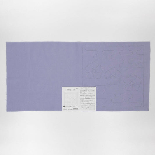 The image is a large purple fabric with a white label attached to it, which appears to be a sewing pattern or instructions.