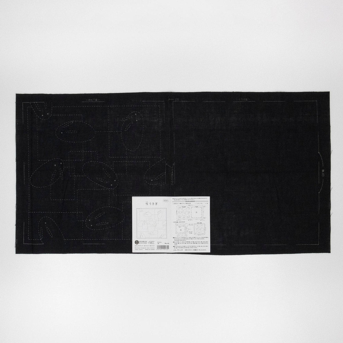 The image is a black square with a white label in the center, which appears to be a piece of paper or a printed document.