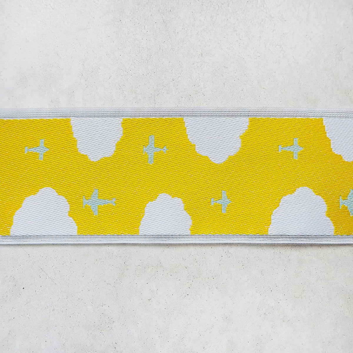 a yellow and white pattern with small airplane shapes on a white background.