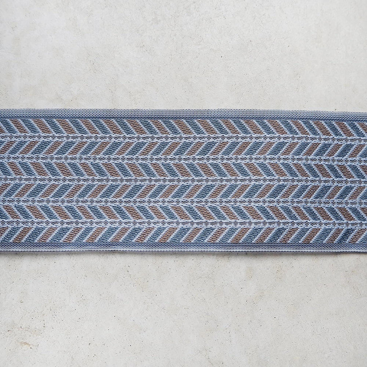 a close-up view of a decorative border or trim with a repeating pattern of blue and brown geometric shapes.