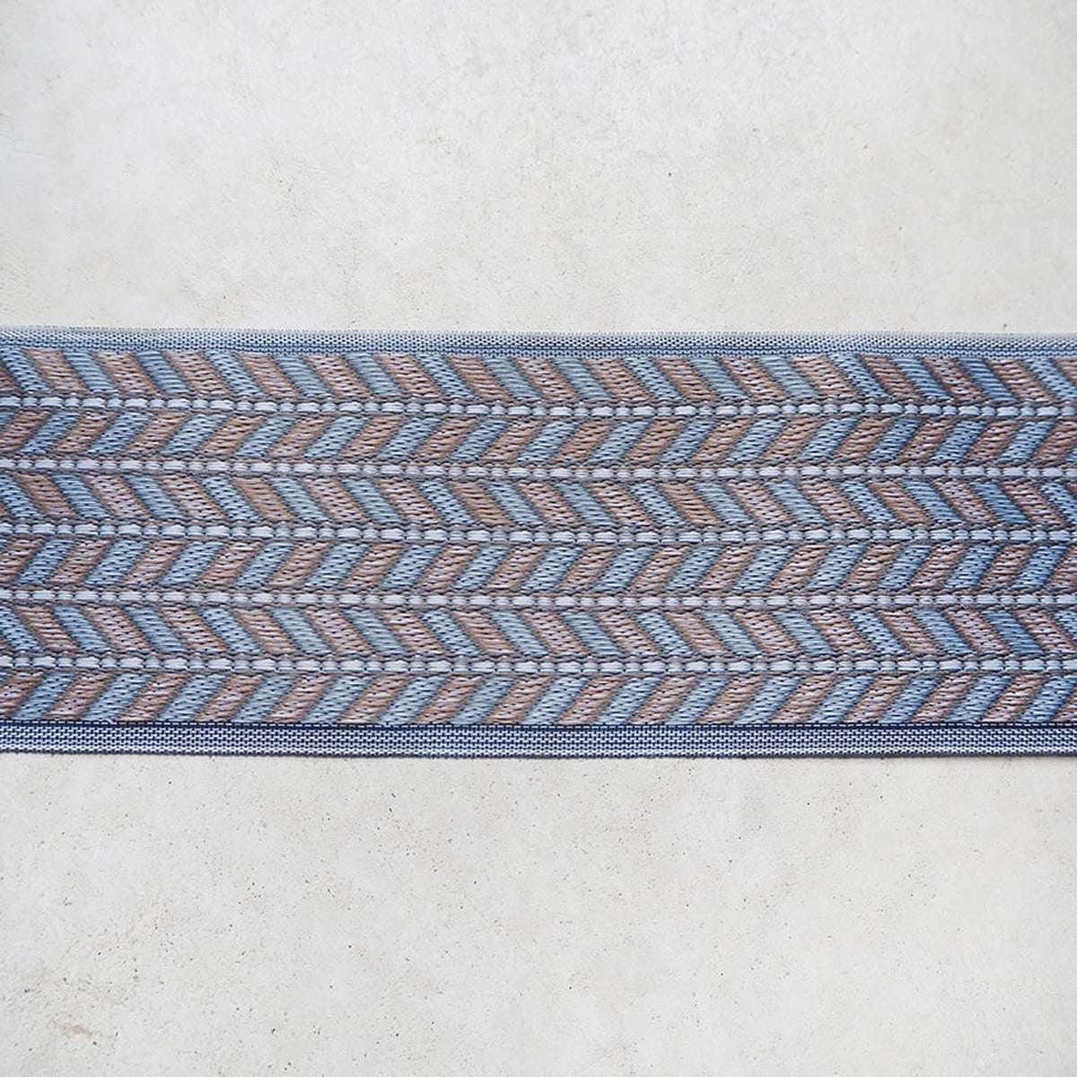a decorative border with a repeating pattern of blue and brown stripes or lines.