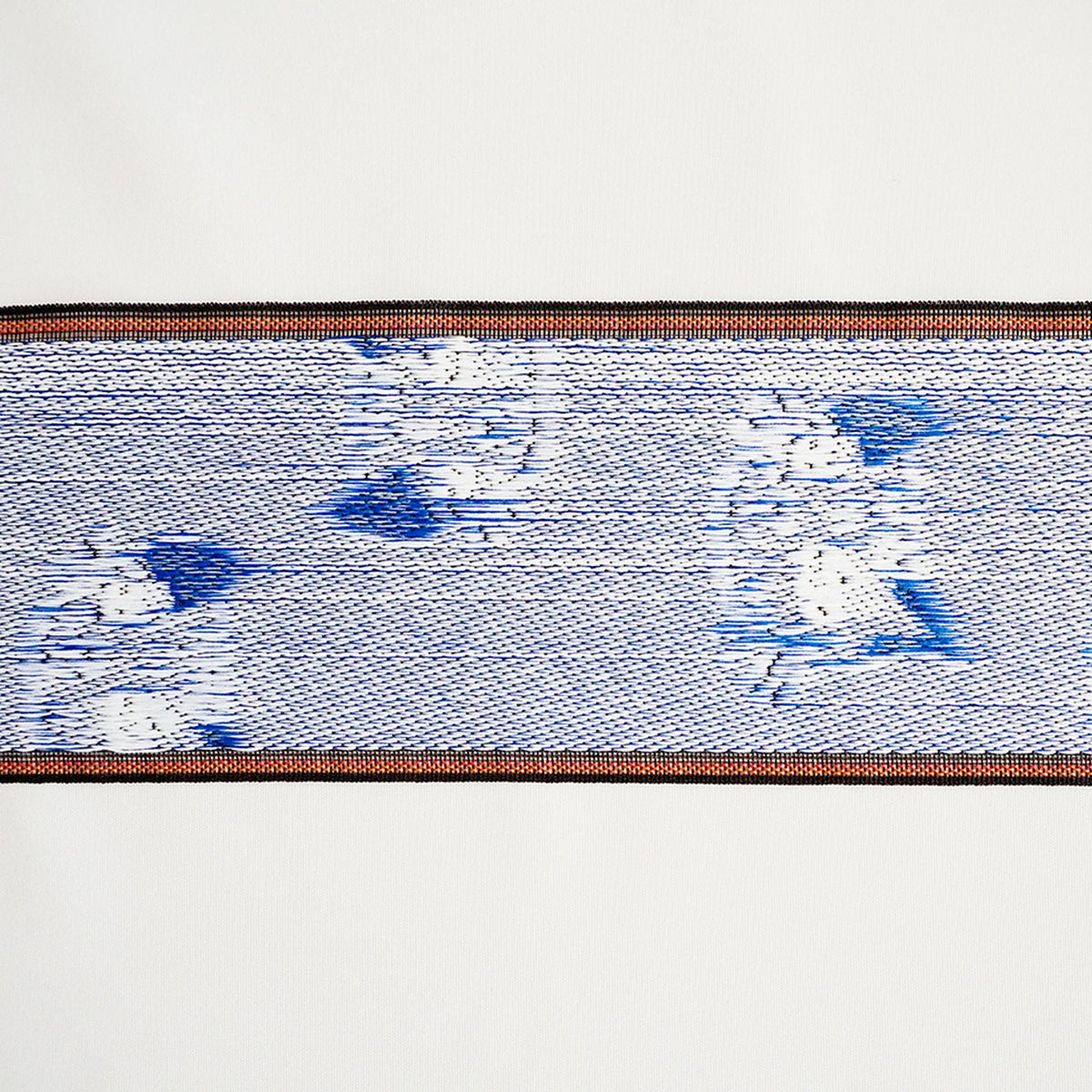 a close-up view of a blue and white patterned fabric, with a black border around it.