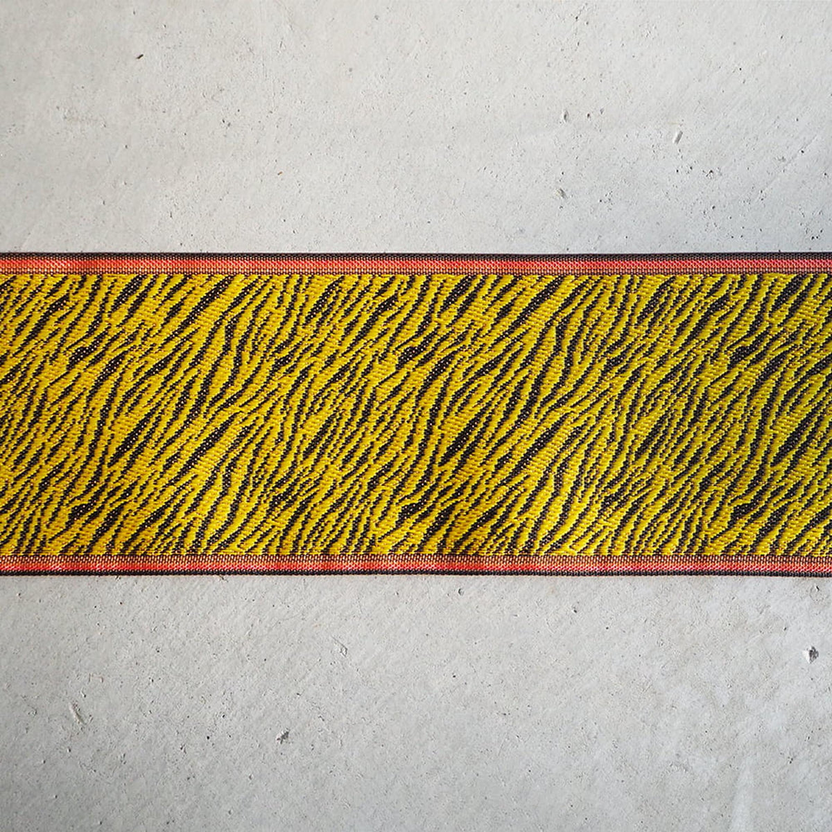 a close-up view of a striped fabric with a bold, zebra-like pattern in yellow and black.