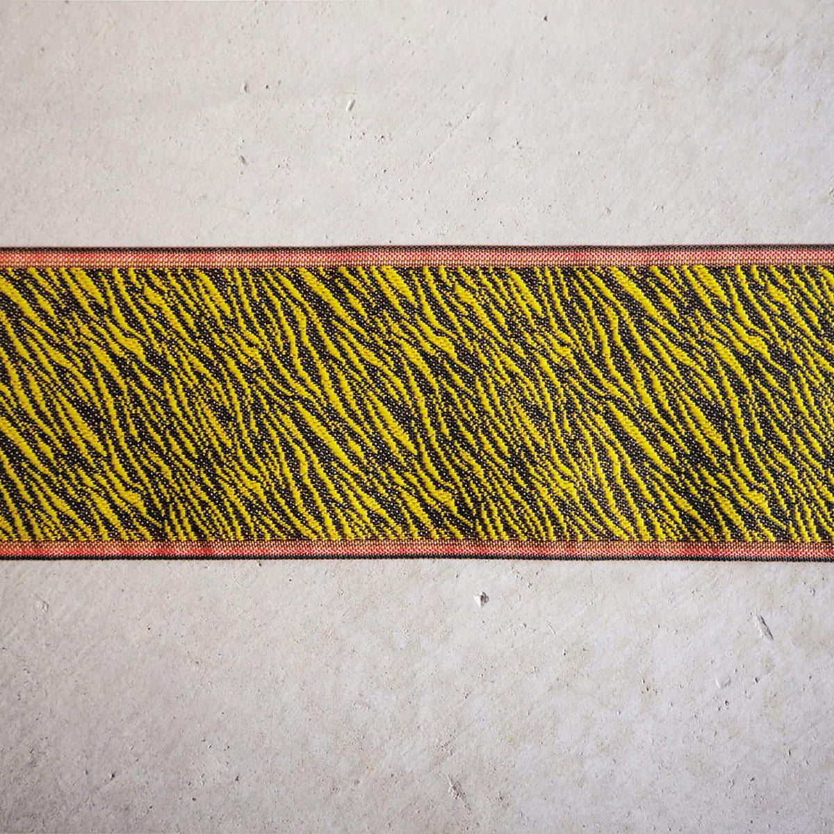 a close-up view of a striped fabric with a bold, zebra-like pattern in shades of yellow and black.