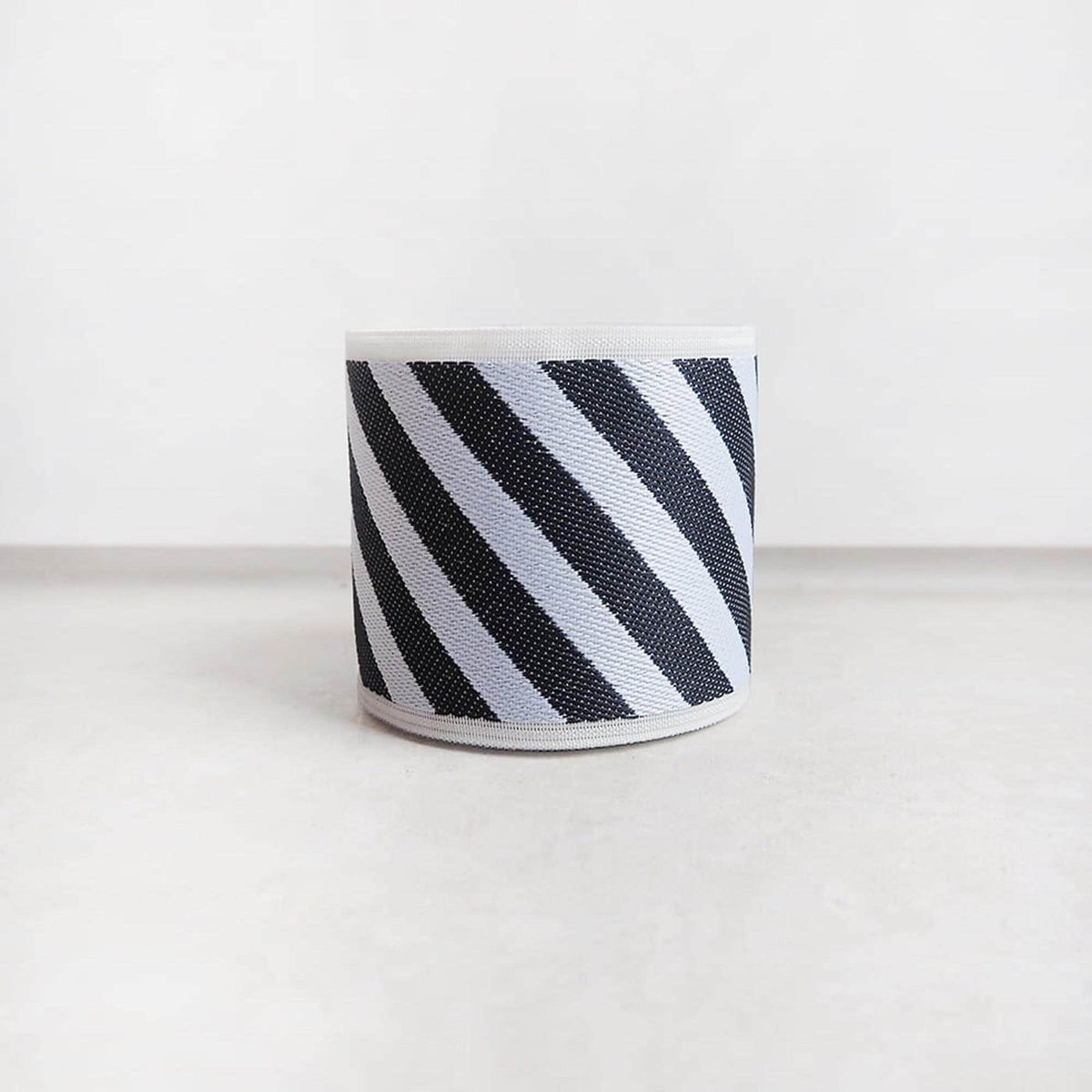 A cylindrical object with a striped pattern in black and white.