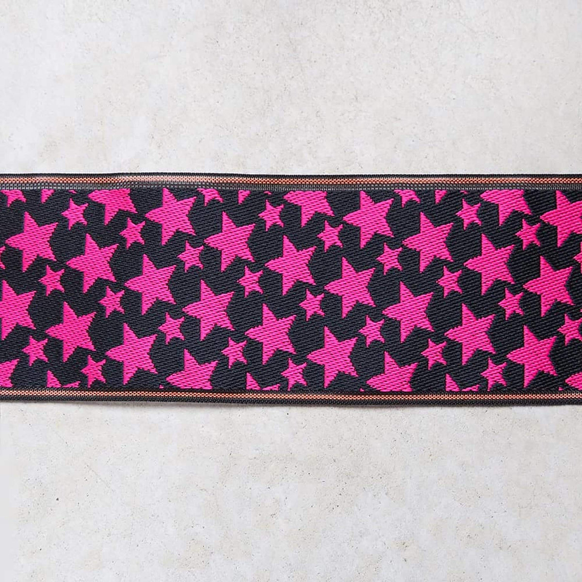 a black and pink star pattern on a fabric or material.