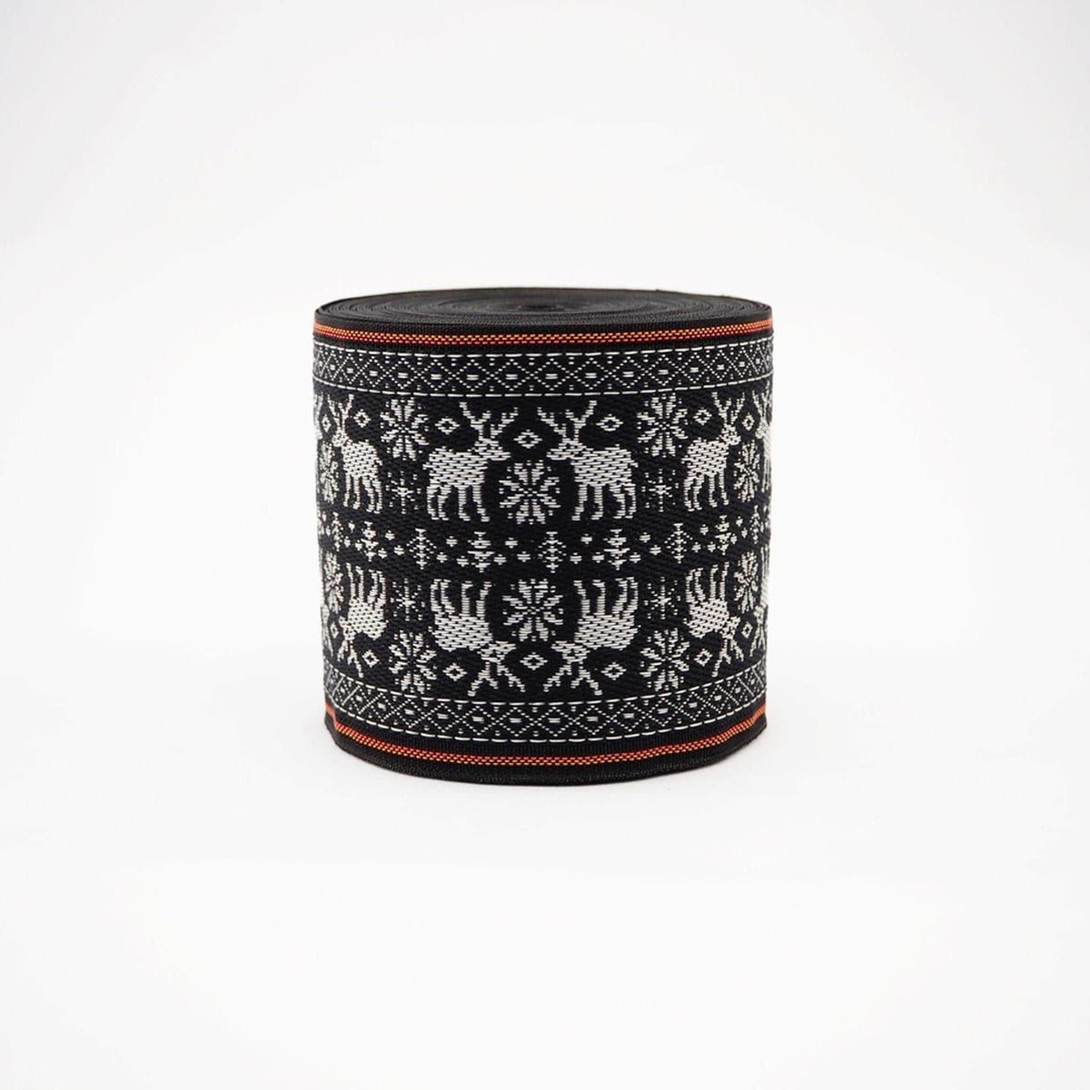 A cylindrical object with a black and white pattern featuring deer and snowflakes.