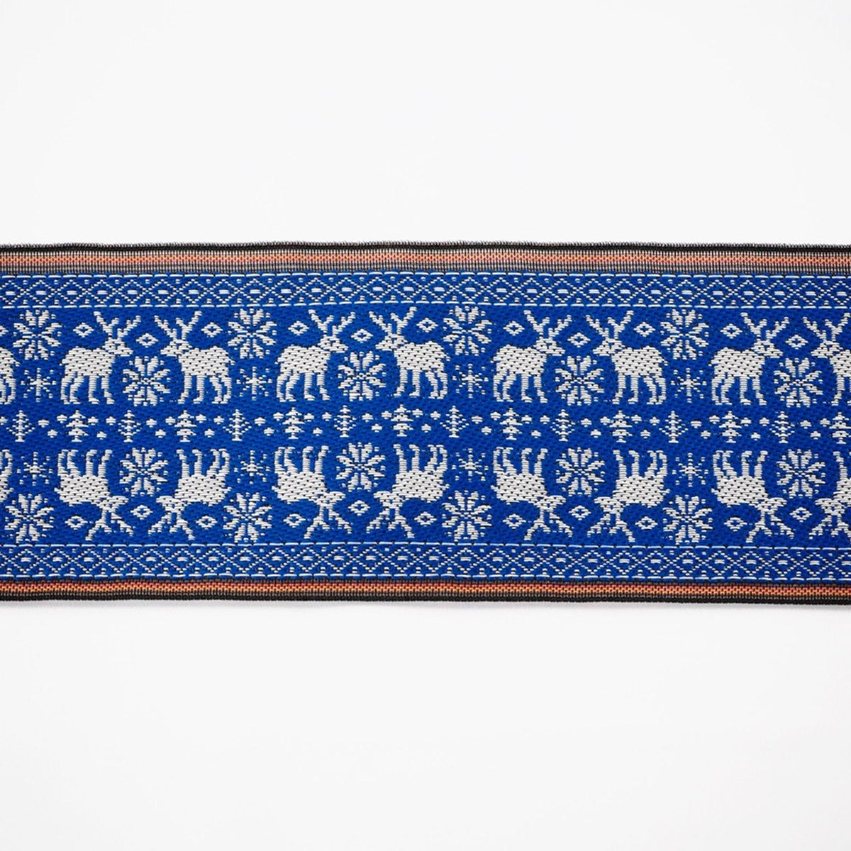 a blue and white patterned fabric with a repeating design of deer and snowflakes.