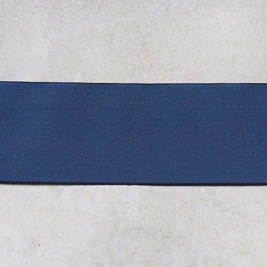 a blue fabric with a diagonal stripe across it, placed on a white surface.
