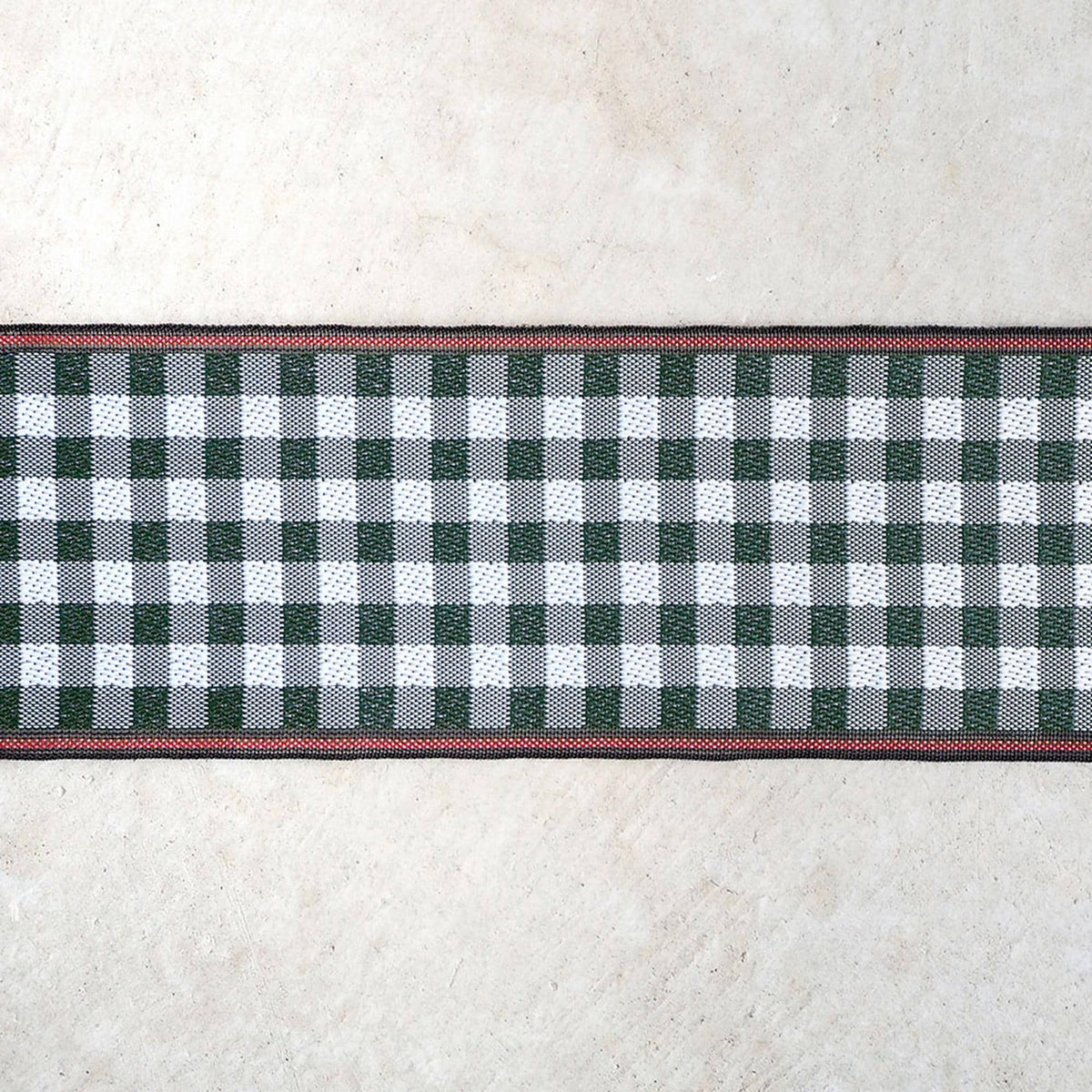 A close-up view of a checkered pattern on a white surface, with a red border around the edge.