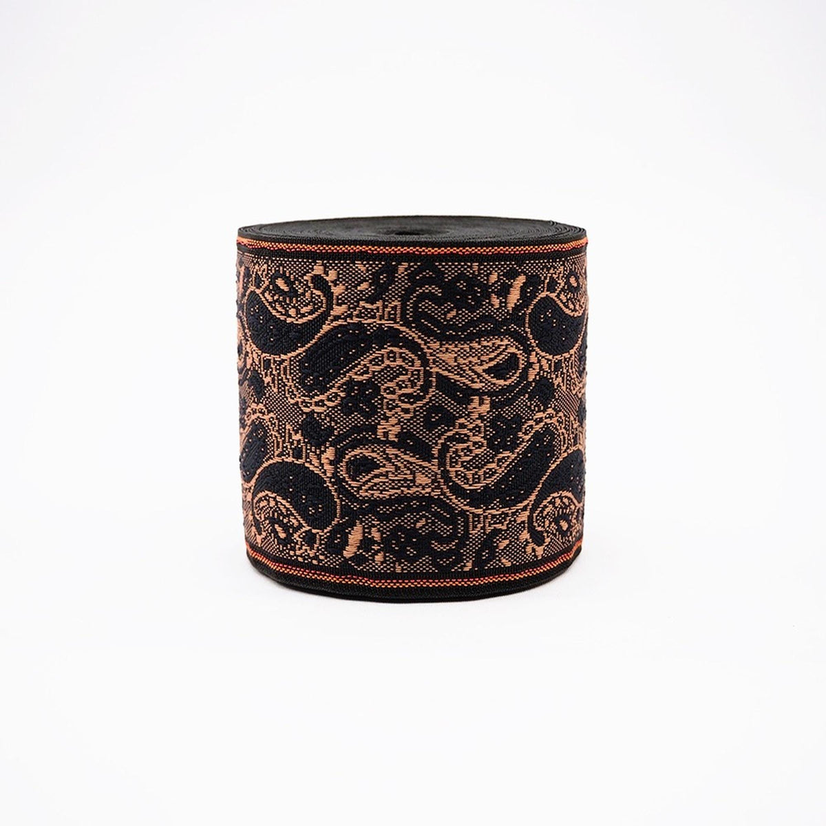 a round, black and gold decorative object with a repeating paisley pattern.