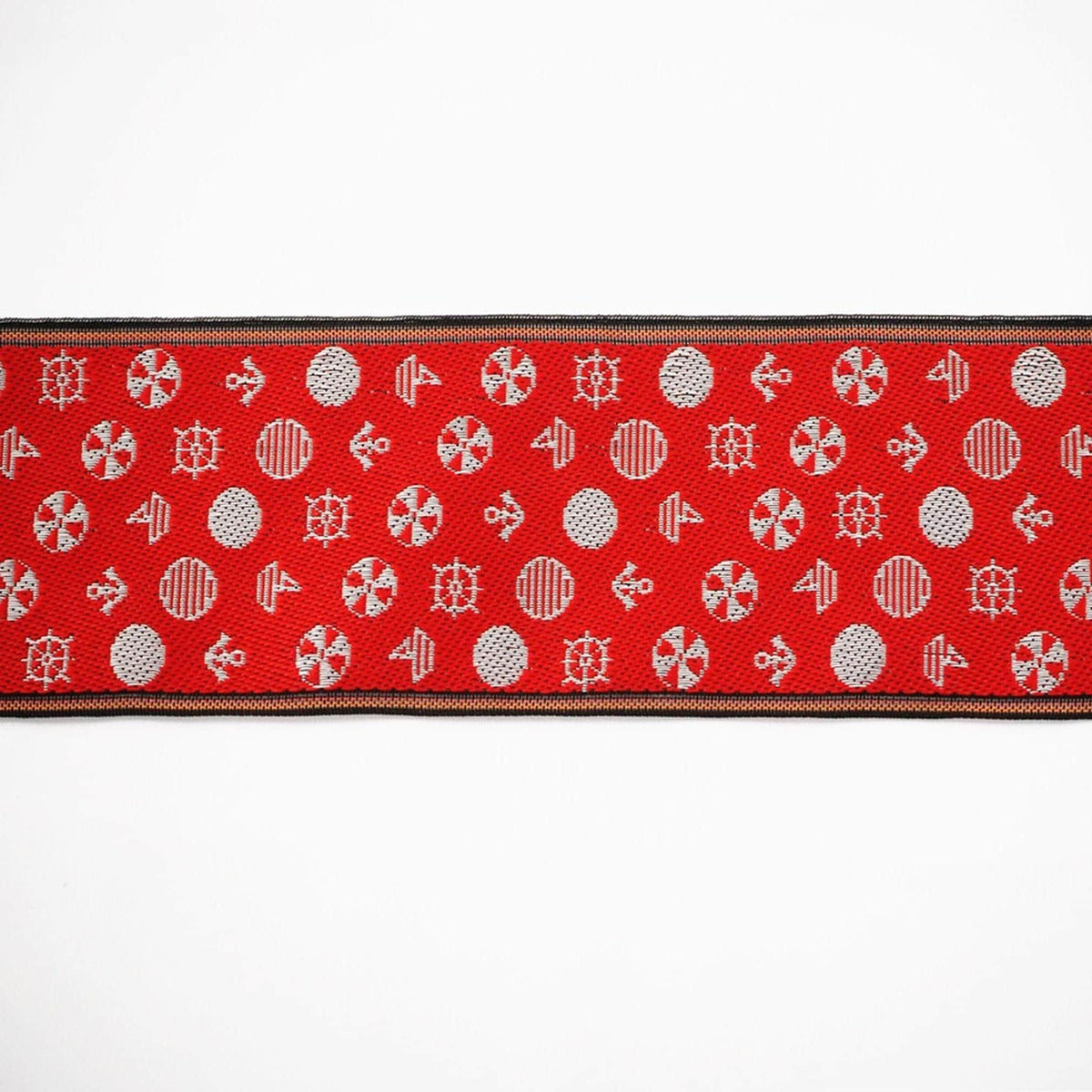 a red fabric with a repeating pattern of white and silver circular shapes, creating a visually striking and intricate design.