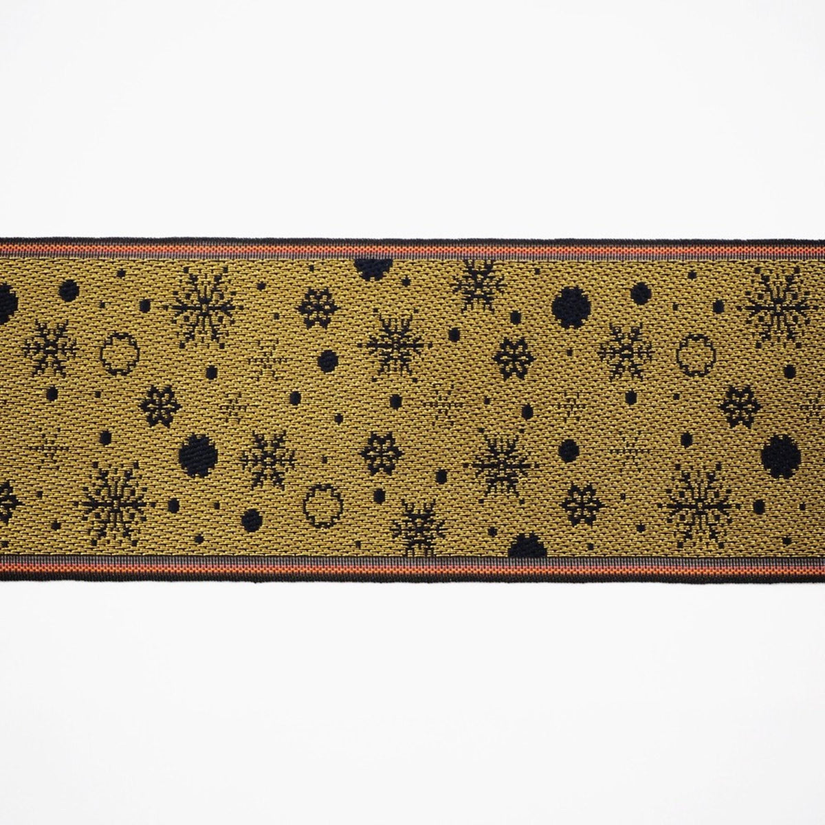 a close-up view of a decorative fabric with a repeating pattern of snowflakes and dots in shades of yellow and black.