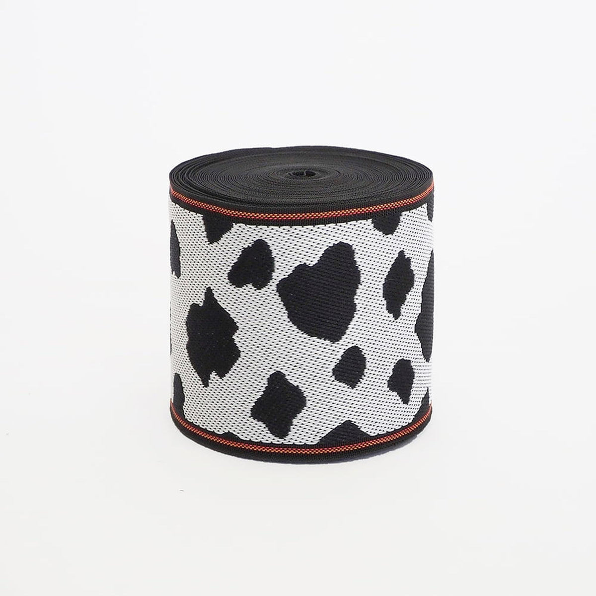 A black and white cow print ribbon is shown against a white background.