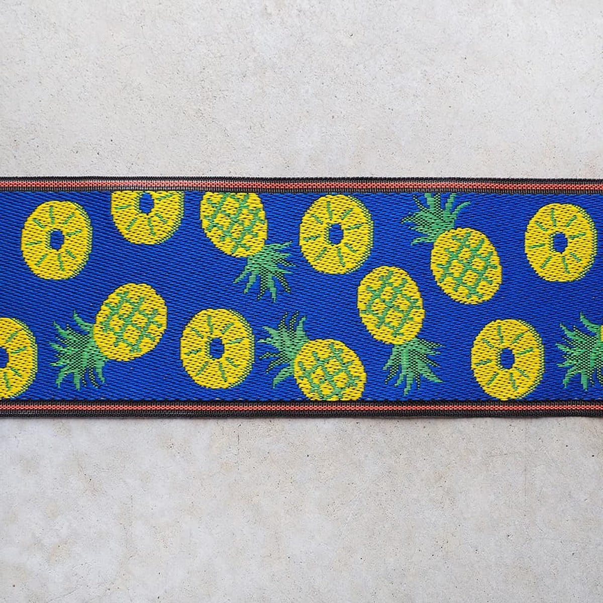 a vibrant blue and yellow pattern with pineapple designs on a blue background.