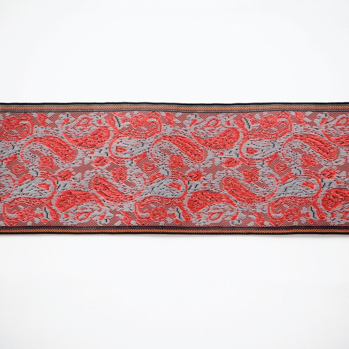 a decorative border with a repeating pattern of red and gray paisley designs.